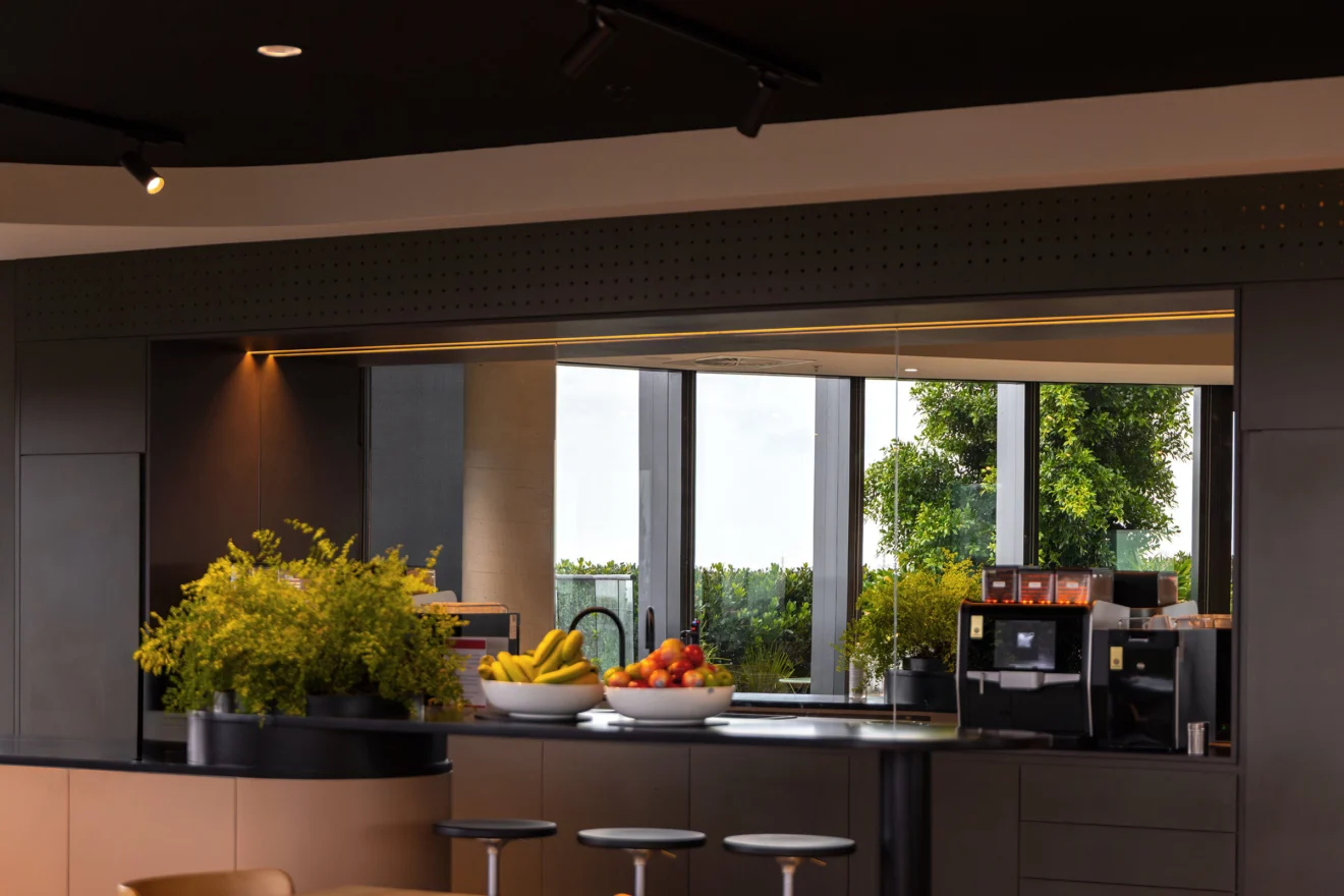 Office kitchen and servery with track lighting at the Acciona head office