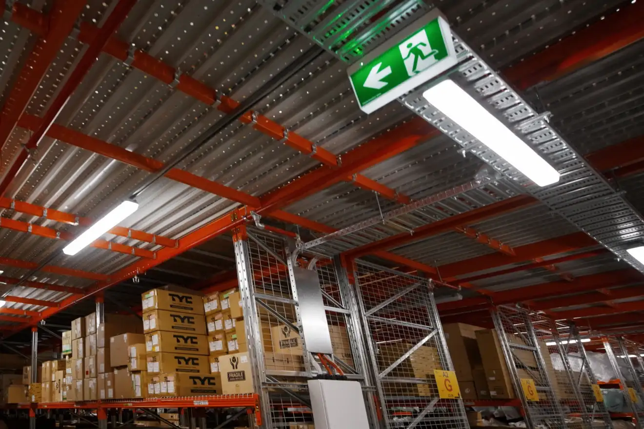Emergency exit sign and LED lighting in the Auto Parts Group warehouse, installed by Marlec Electrical