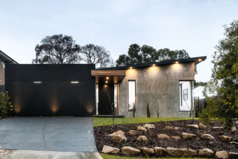 Modern house front lit by outdoor lights at dusk