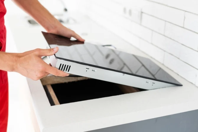 Induction cooktop being set into a kitchen bench