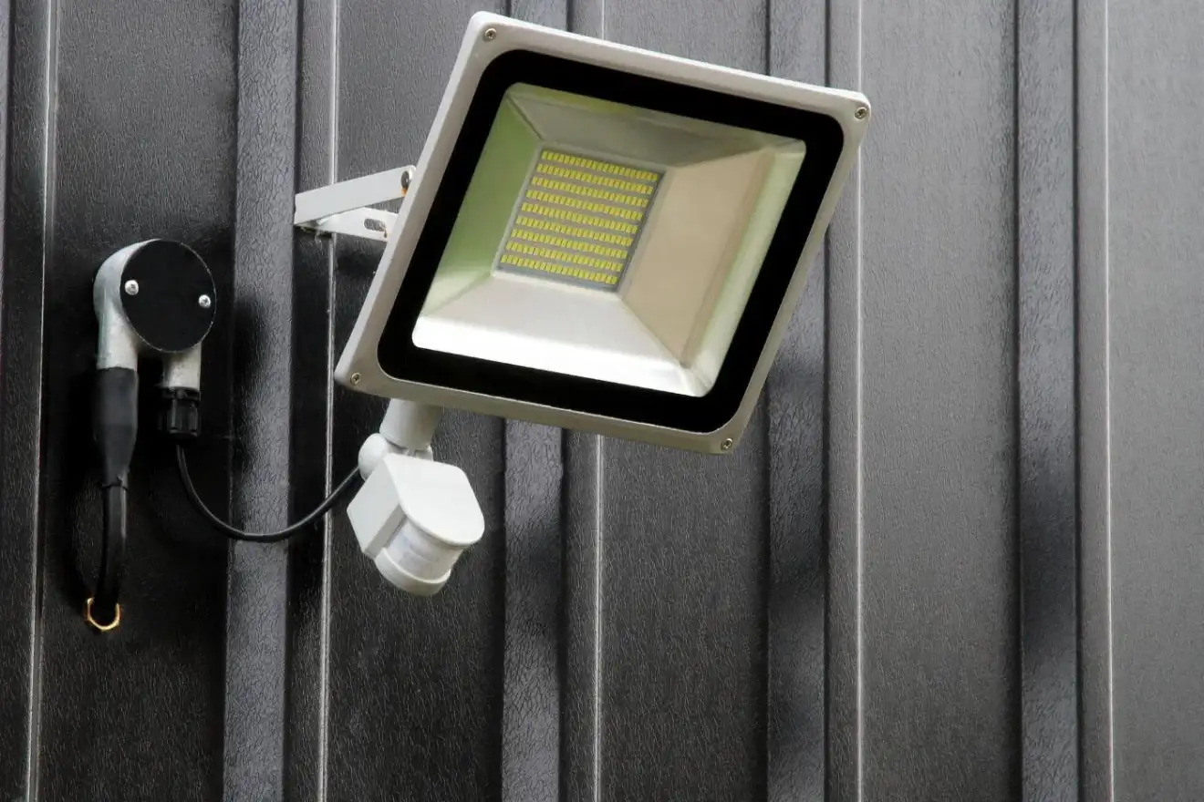 LED floodlight with motion sensor on an outside wall