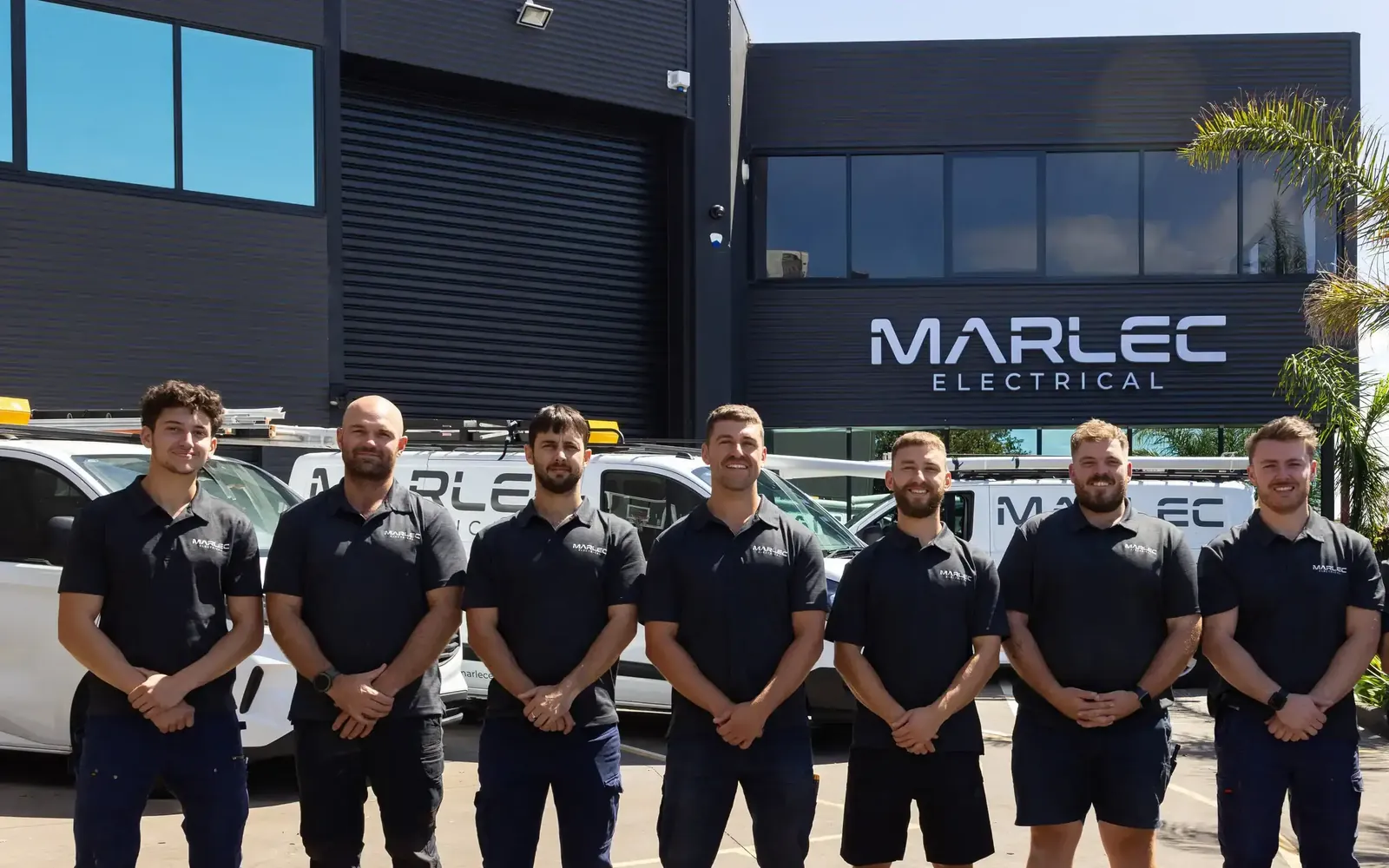 The Marlec Electrical team in their dark-grey uniforms outside the Marlec workshop