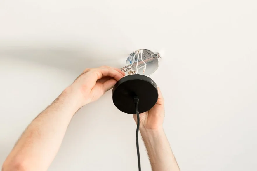 Pendant light being fitted to a ceiling
