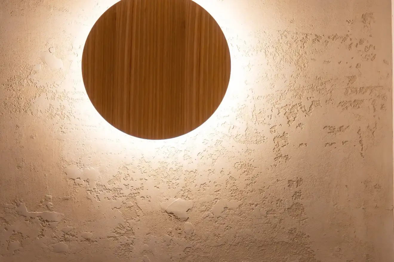 Round backlit timber wall light at The Sebel Melbourne